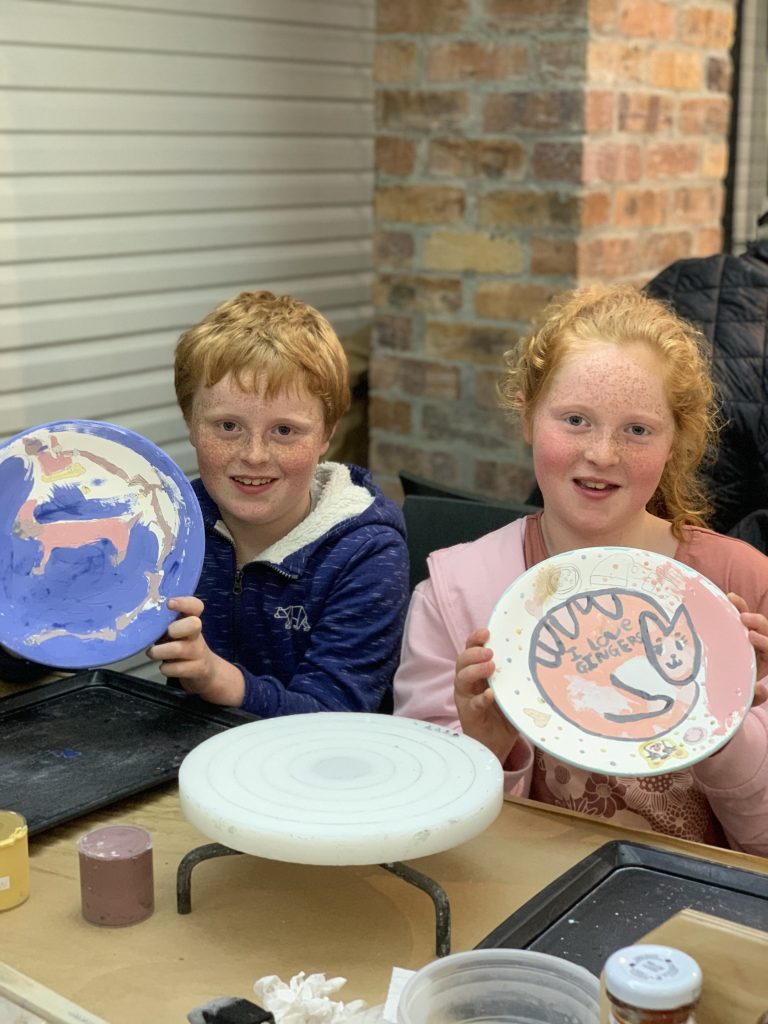 Siblings enhancing motor skills at the Clay Café in Hout Bay.