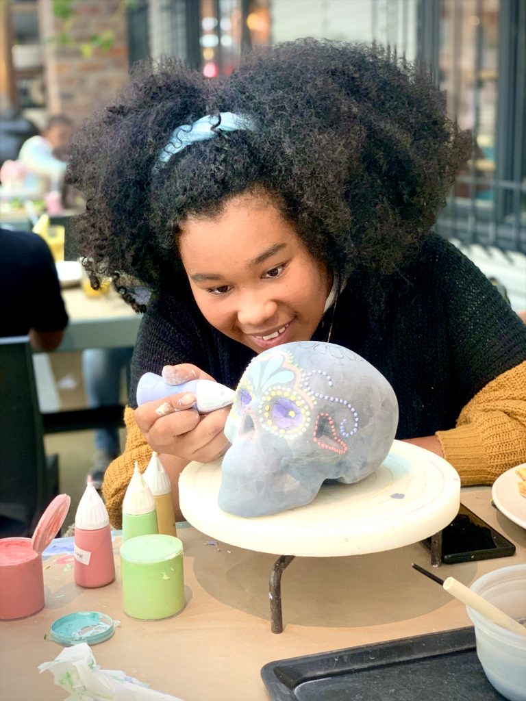 Young girl fostering focus and concentration at the Clay Café in Hout Bay.