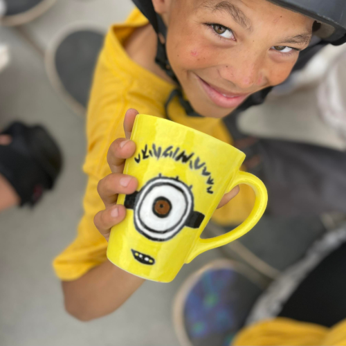 A heartwarming smile on the face of one of the children who received a donated mug from the paint  donate initiative.